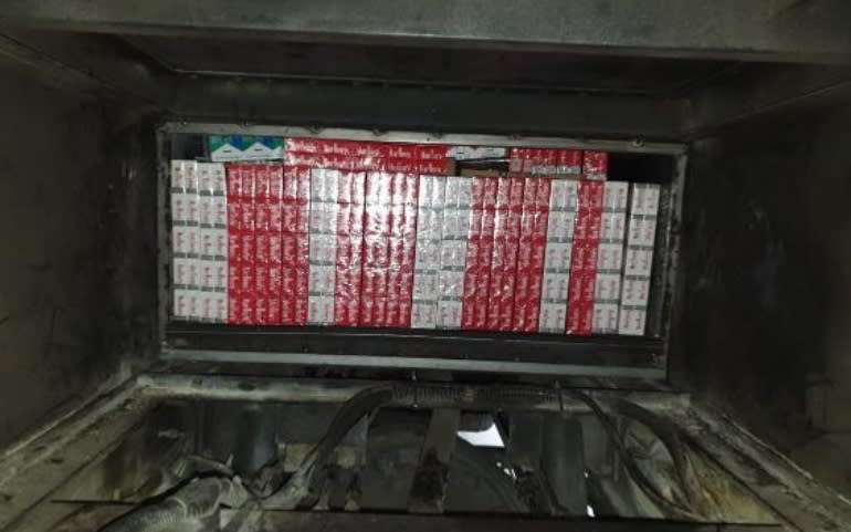 Duty-unpaid cigarettes concealed in the modified compartment underneath the floorboard of a Malaysia-registered bus were uncovered by ICA at Tuas Checkpoint. (Photo: Immigration and Checkpoints Authority)