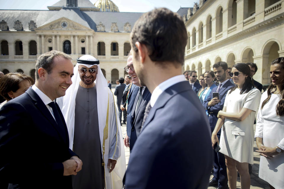 France's Defense Minister Sebastien Lecornu, left, and United Arab Emirates' President Sheikh Mohammed Bin Zayed meet officials during a welcome ceremony at the Invalides monument in Paris, Monday, July 18, 2022. United Arab Emirates' President Sheikh Mohammed Bin Zayed is for a two-days visit in France. (AP Photo/Thomas Padilla, Pool)
