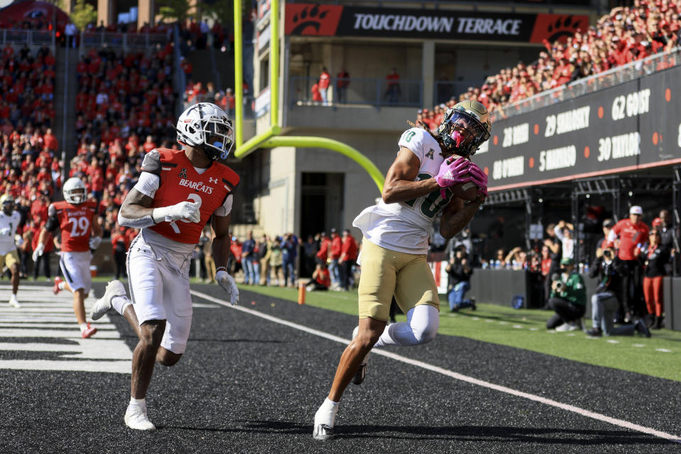 South Florida wide receiver Xavier Weaver, right, catches a touchdown pass against Cincinnati safety Ja'von Hicks during the first half of an NCAA college football game, Saturday, Oct. 8, 2022, in Cincinnati. (AP Photo/Aaron Doster)