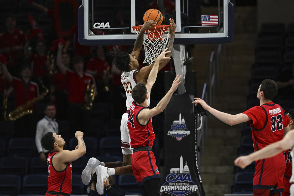 Charleston forward James Scott (23) is fouled while attempting a dunk by Stony Brook guard Jared Frey during the first half of an NCAA college basketball game in the championship of the Coastal Athletic Association conference tournament, Tuesday, March 12, 2024, in Washington. (AP Photo/Terrance Williams)