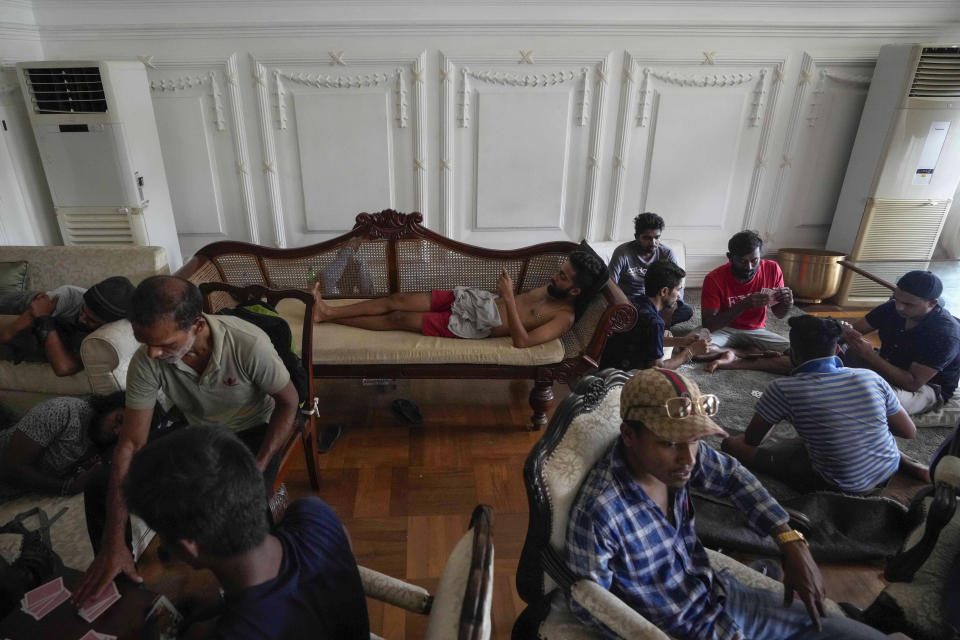 Protesters stay and play cards in prime minister's official residence a day after it was stormed in Colombo, Sri Lanka, Sunday, July 10, 2022. Sri Lanka’s president and prime minister agreed to resign Saturday after the country’s most chaotic day in months of political turmoil, with protesters storming both officials’ homes and setting fire to one of the buildings in a rage over the nation's severe economic crisis. (AP Photo/Eranga Jayawardena)