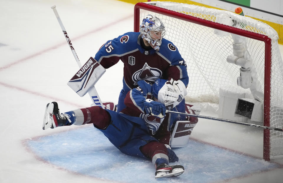 Colorado Avalanche center Nazem Kadri, front, slides into goaltender Darcy Kuemper after he deflected a shot by the Tampa Bay Lightning during the second period of Game 5 of the NHL hockey Stanley Cup Final, Friday, June 24, 2022, in Denver. (AP Photo/David Zalubowski)