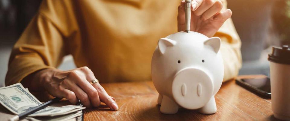 woman hand putting money bank note dollar into piggy for saving money wealth and financial concept.