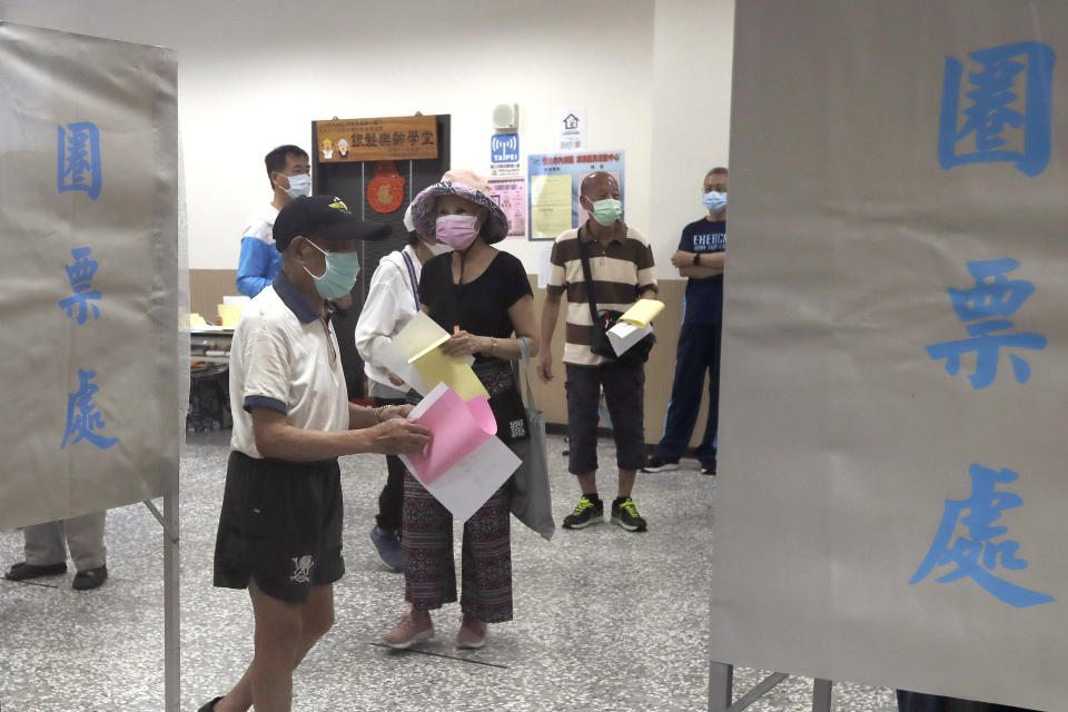 Members of the Nationalist Party, or KMT, prepare to cast their ballot for election of its party chairman at a polling station in Taipei, Taiwan, Saturday, Sept. 25, 2021. Fraught relations with neighboring China are dominating Saturday's election for the leader of Taiwan’s main opposition Nationalist Party. (AP Photo/Chiang Ying-ying)