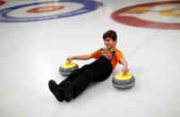 A Yazidi refugee from Kurdistan laughs as he learns the sport of curling at the Royal Canadian Curling Club during an event put on by the "Together Project", in Toronto, March 15, 2017. REUTERS/Mark Blinch