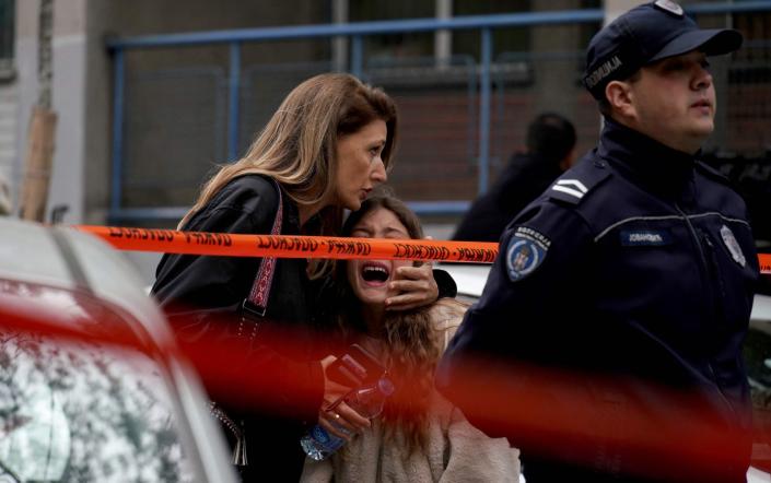 A parent comforts her child at the school in Serbia after the shooting - Oliver Bunic/AFP via Getty Images