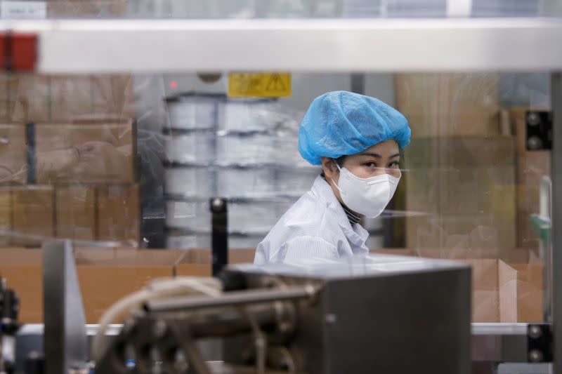 An employee works in an assembly line at a mask factory in Icheon