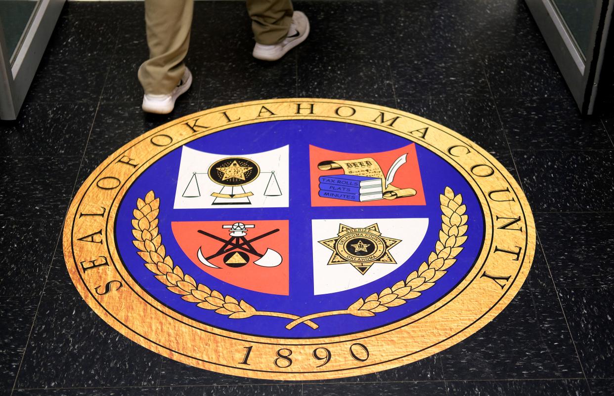 A person walks past Oklahoma County's seal outside the Board of County Commissioners meeting chamber on Monday.