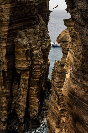 This photo made available by Red Bull shows Kent De Mond of the USA diving 29 metres from the rock monolith during the first round of the third stop of the Red Bull Cliff Diving World Series in Islet Vila Franca do Campo, Azores, Portugal, Friday July 20, 2012. Kent De Mond of the USA leads after the first round with the remaining three rounds taking place Saturday. (AP Photo/Dean Treml)