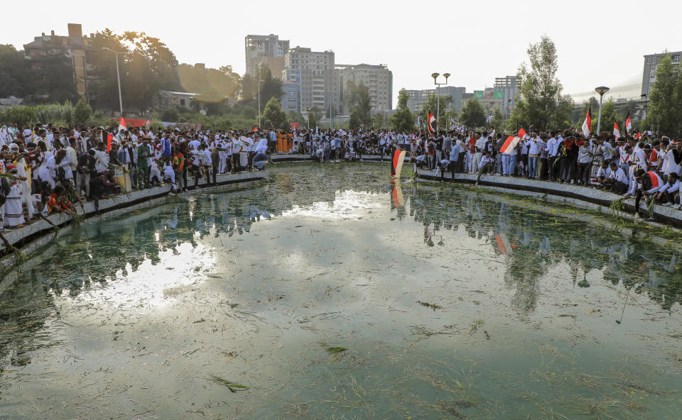 Oromos throw grass and flowers into a pool of water as they celebrate the annual Irreecha festival in the capital Addis Ababa, Ethiopia, Saturday, Oct. 2, 2021. Ethiopia's largest ethnic group, the Oromo, on Saturday celebrated the annual Thanksgiving festival of Irreecha, marking the end of winter where people thank God for the blessings of the past year and wish prosperity for the coming year. (AP Photo)