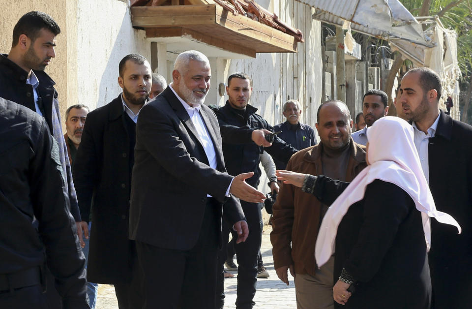 Hamas' supreme leader Ismail Haniyeh shakes Hans with a woman at the site of a destroyed building, in Gaza City, Wednesday, March 27, 2019. Haniyeh made his first public appearance since a new round of cross-border violence with Israel this week. On Wednesday he visited the rubble of his Gaza City office, which was destroyed in an Israeli airstrike. (AP Photo/Adel Hana)