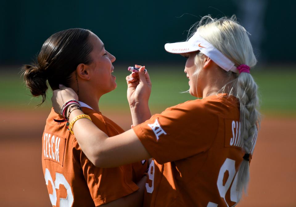 Longhorn Sophia Simpson applies lip balm for fellow pitcher Estelle Czech before a game in March. Czech, a sophomore, pitched a five-hit shutout Friday.