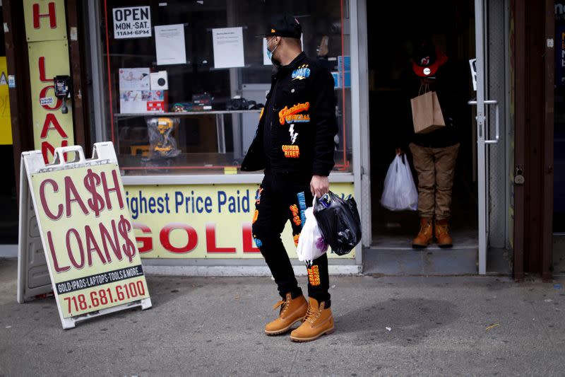 Men leave pawn shop offering loans during outbreak of coronavirus disease (COVID-19) in Bronx borough of New York