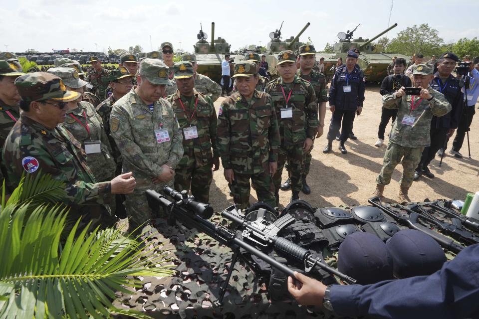 Gao Xiucheng, third from left, deputy chief of staff of the Southern Theater Commander of the Chinese People's Liberation Army, takes a tour during the Golden Dragon military exercise in Svay Chok village, Kampong Chhnang province, north of Phnom Penh, Cambodia, Thursday, May 16, 2024. Cambodia and China began half-month long military exercises on Thursday, which come amid growing questions about Beijing's increasing influence in the Southeast Asian nation. (AP Photo/Heng Sinith)