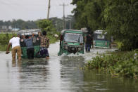 People push auto rickshaws through a flooded road in Bagha area in Sylhet, Bangladesh, Monday, May 23, 2022. Pre-monsoon deluges have flooded parts of India and Bangladesh, killing at least 24 people in recent weeks and sending 90,000 people into shelters, authorities said Monday. (AP Photo)