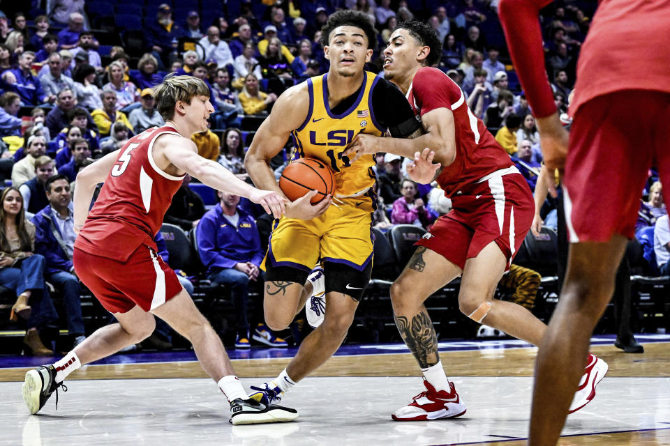 LSU forward Corey Chest (11) charges toward the basket while guarded by Arkansas guard Joseph Pinion (5) and forward Jalen Graham (11) during an NCAA college basketball game at Pete Maravich Assembly Center, Saturday, Feb. 3, 2024, Baton Rouge, La. (Javier Gallegos/The Advocate via AP)