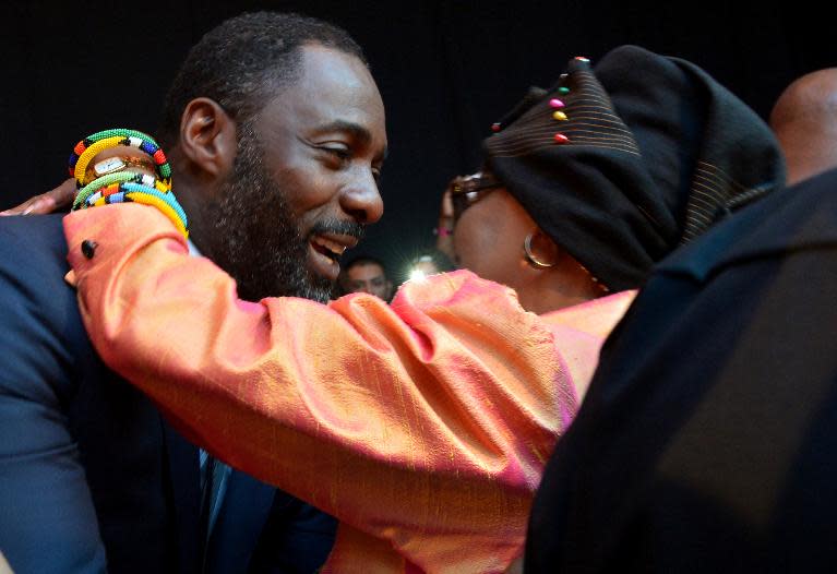 Nelson Mandela's second wife Winnie Madikizela–Mandela (R) and British actor Idris Elba hug each other as they attend the movie's premiere in Johannesburg on November 3, 2013