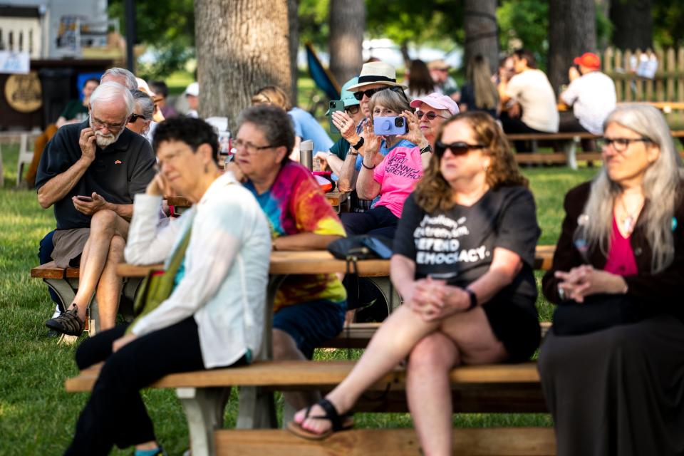 People listen to speakers during a celebration rally at the Des Moines Biergarten at Water Works Park on Friday.