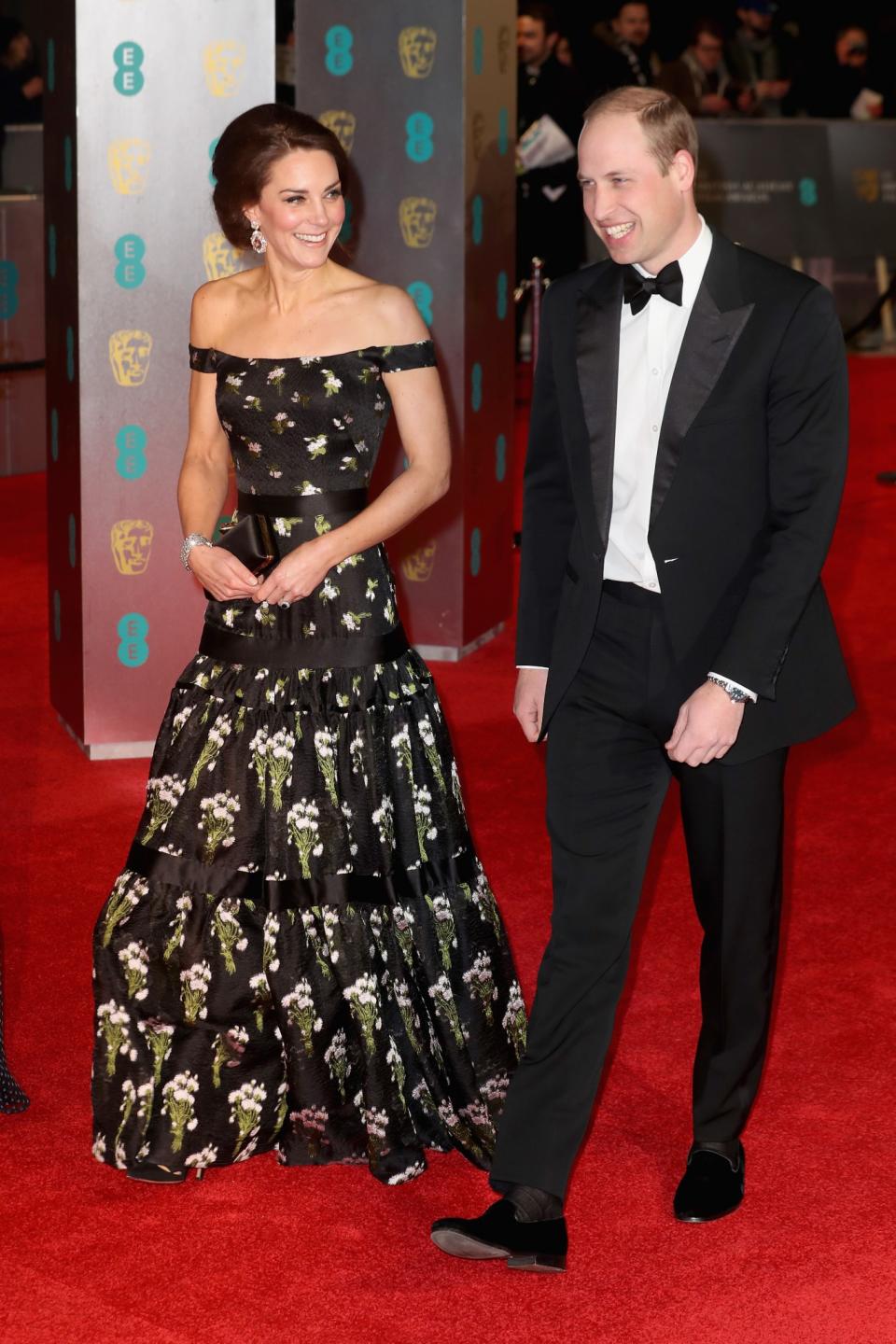 <p>Für die British Academy Film Awards 2017 wählte Kate ein gotisch angehauchtes Kleid von Alexander McQueen. Das Kleid wurde mit Blumen bedruckt und schulterfrei gestaltet. Die Herzogin kombinierte das dunkle Ensemble mit schwarzen Pumps und einer dazu passenden McQueen-Clutch aus Satin. (Bild: PA) </p>