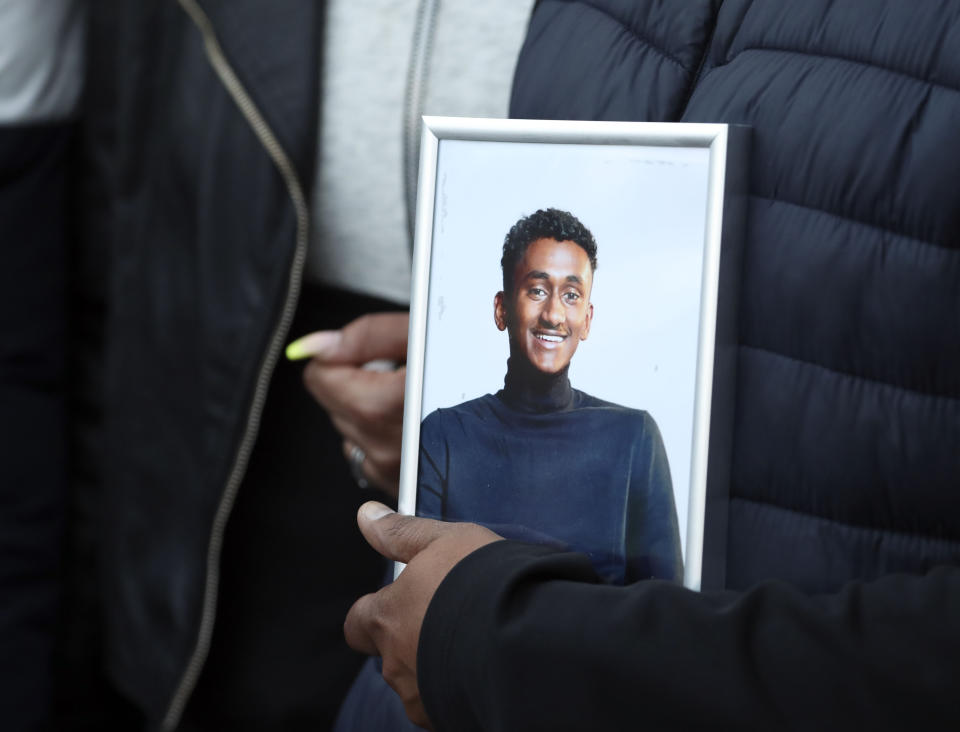 Chandima Daniel, father of Tashan Daniel, who was stabbed at Hillingdon station whilst on his way to an Arsenal game on Tuesday, holds a photograph of him at a vigil held outside the underground station in London.