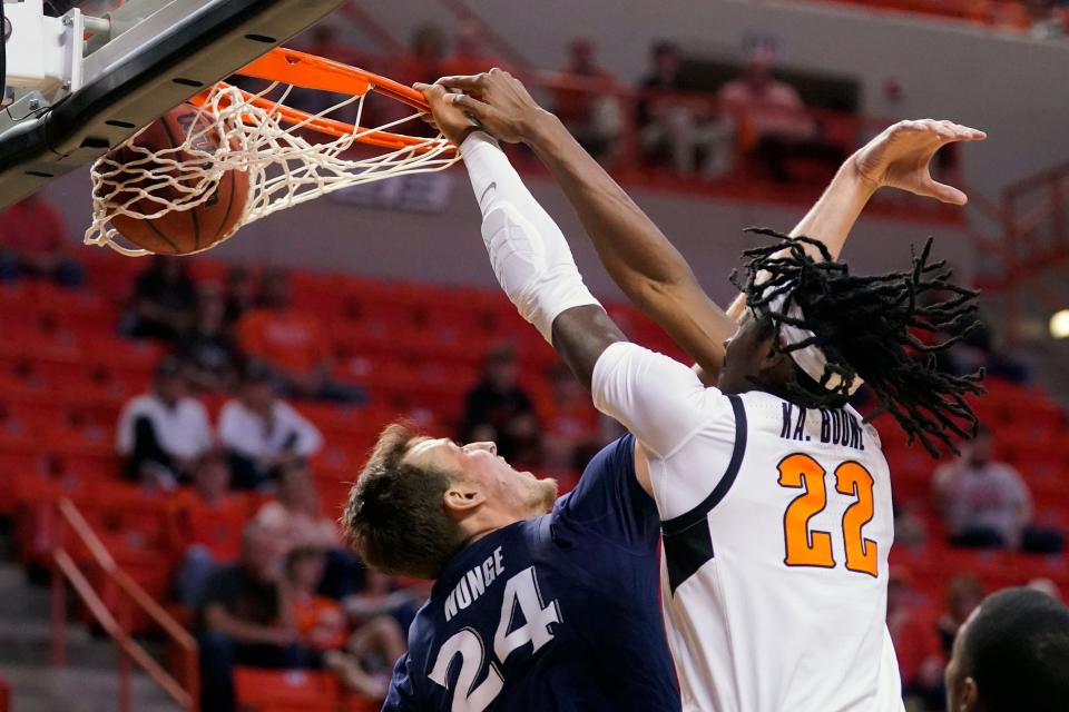 Oklahoma State forward Kalib Boone (22) dunks over Xavier forward Jack Nunge (24) during Sunday's game in Gallagher-Iba Arena in Stillwater.