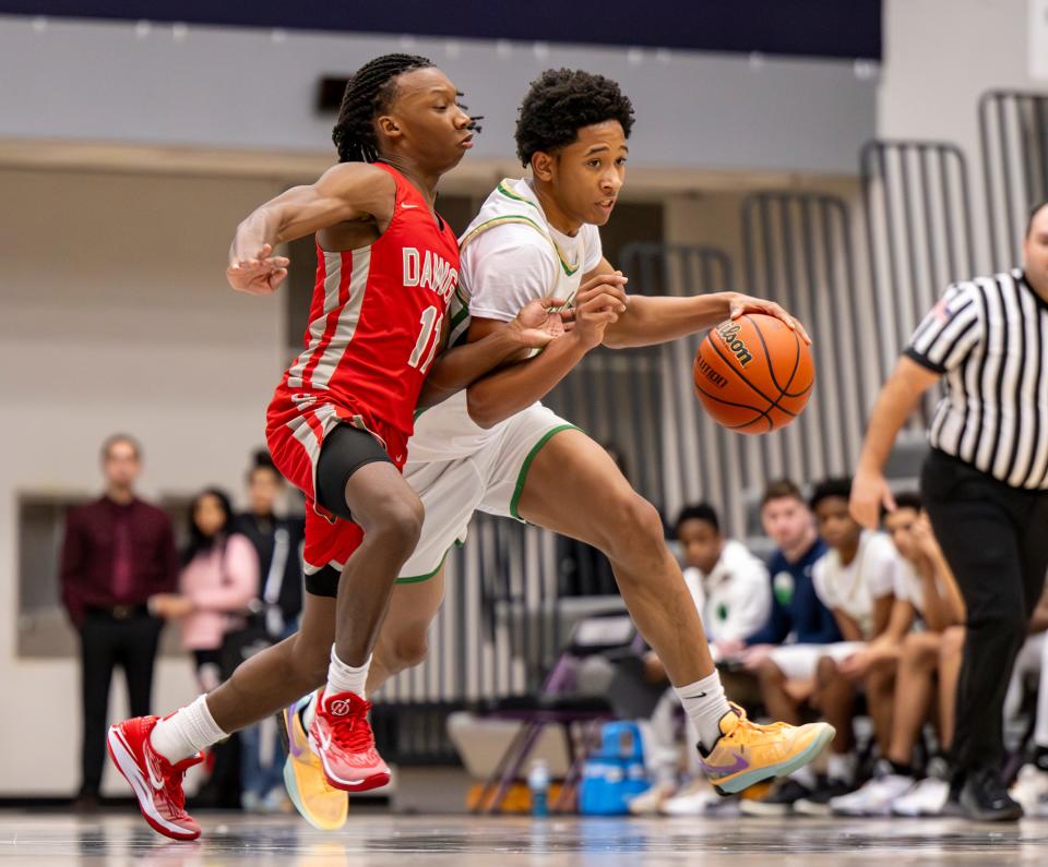 Evansville Bosse High School senior Taray Howell (11) defends Indianapolis Cathedral High School senior Anthony Fields (13) as he brings the ball up court during the first half of a varsity game in the SNKRS4SANTA Shootout, Saturday, Dec. 2, 2023, at Brownsburg High School.