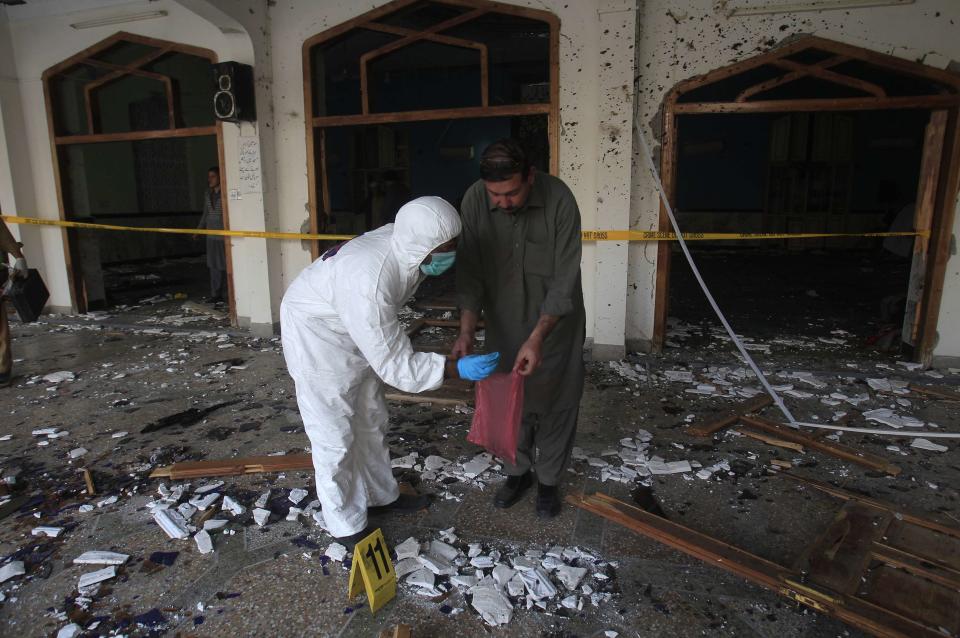 Security officials collect evidence from the site of an explosion in a Shi'ite mosque in Peshawar