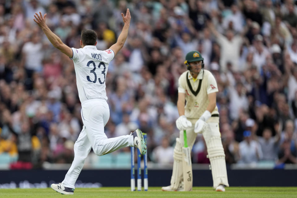 England's Mark Wood, left, celebrates the dismissal of Australia's Marnus Labuschagne, right, during the second day of the fifth Ashes Test match between England and Australia at The Oval cricket ground in London, Friday, July 28, 2023. (AP Photo/Kirsty Wigglesworth)