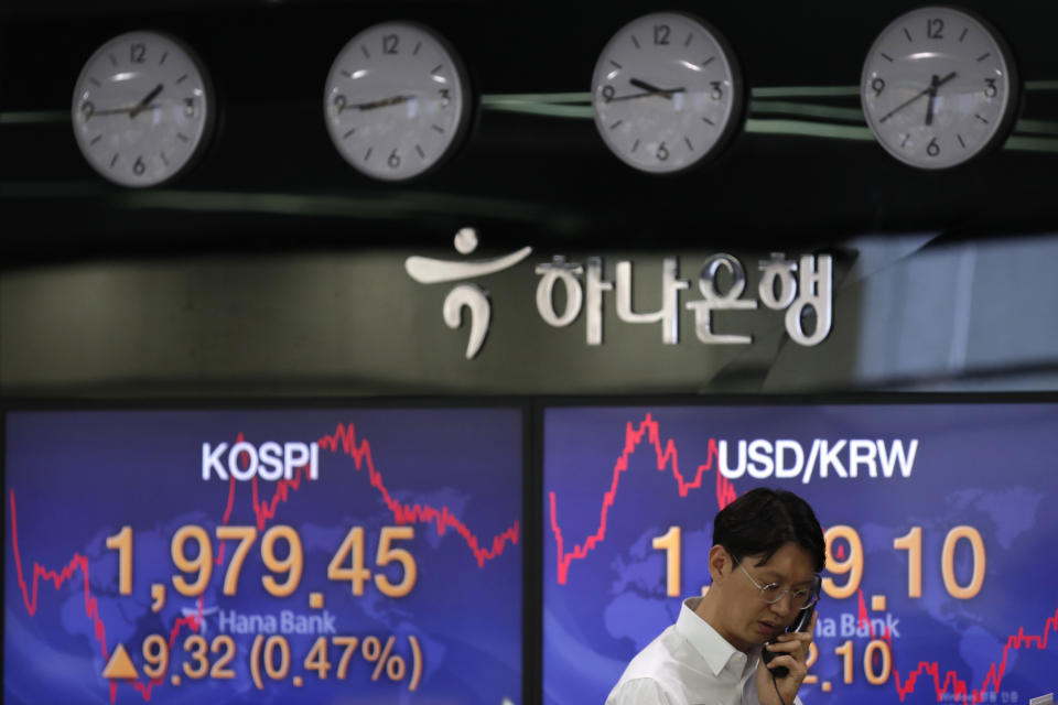 A currency trader talks on the phone near the screens showing the Korea Composite Stock Price Index (KOSPI), left, and the foreign exchange rate between U.S. dollar and South Korean won at the foreign exchange dealing room in Seoul, South Korea, Monday, May 25, 2020. Asian shares are mostly higher, with Tokyo stocks gaining on expectations that a pandemic state of emergency will be lifted for all of Japan. But shares fell in Hong Kong on Monday after police used tear gas to quell weekend protests over a proposed national security bill for the former British colony. (AP Photo/Lee Jin-man)