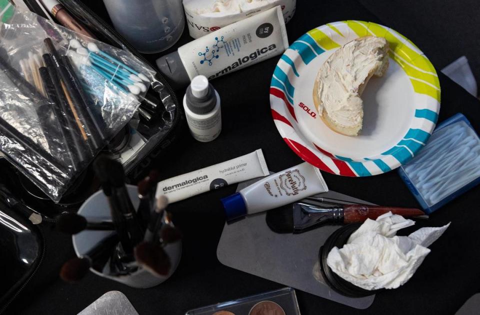 Lee’s makeup table, pictured before she had the chance to organize the makeup by actor. She took bites of her bagel with cream cheese in between doing actors’ makeup, making sure to sanitize her hands before touching the makeup and the actors. Lauren Witte/lwitte@miamiherald.com