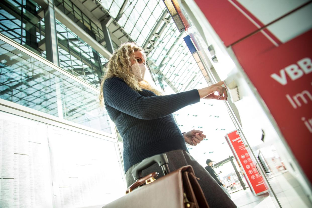 Eine Frau mit FFP2-Maske kauft sich in Berlin ein Zugticket am Automaten. Bald soll dort bundesweit auch das Neun-Euro-Ticket erhältlich sein.