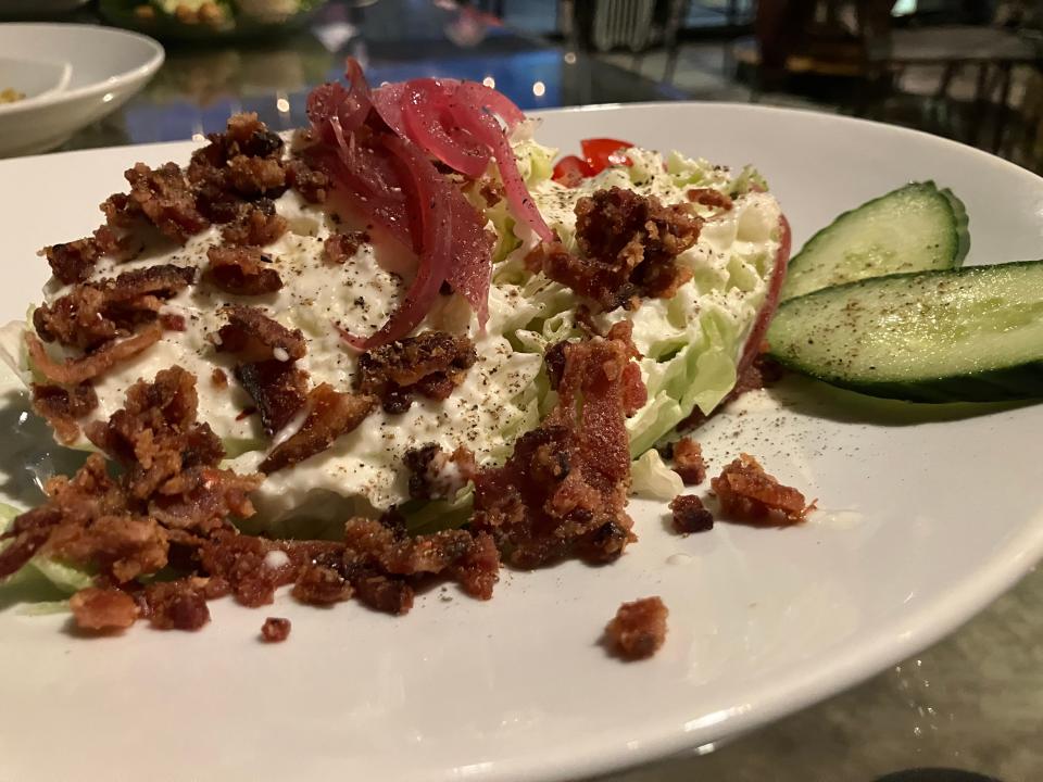 A mini wedge salad topped with bacon, pickled onions, cucumber, grape tomatoes and 35º Brix's renowned white French dressing.