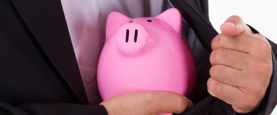 Pink piggy bank in safe with businessman in suit, isolated on white background.