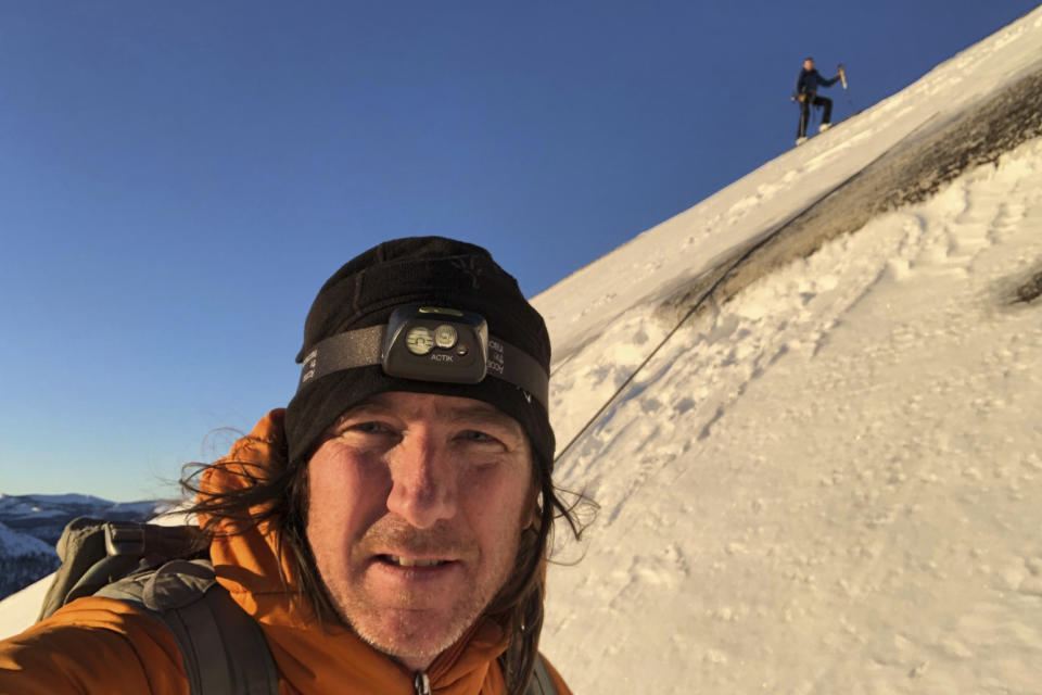 In this photo provided by Jason Torlano, he poses with his friend, Zach Milligan, right, on their descent down Half Dome in Yosemite National Park, Calif., on Sunday, Feb. 21, 2021. Two men climbed some 4,000 feet to the top of Yosemite's Half Dome in subfreezing temperatures and skied down the famously steep monolith to the valley floor. Torlano, 45, and Milligan, 40, completed the daring descent in five hours on Sunday by charging down Half Dome's arching back and using ropes to rappel down several sections of bare rock known as the "death slabs," the Fresno Bee reported on Thursday. (Jason Torlano via AP)
