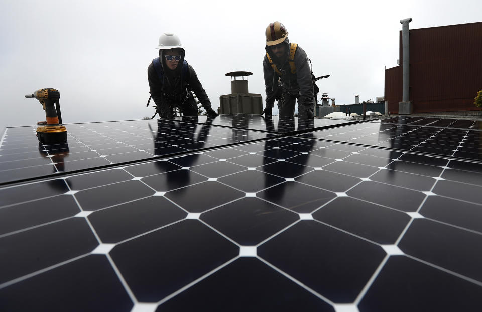 Workers install solar panels on the roof of a home in San Francisco on May 9. (Photo: Justin Sullivan/Getty Images)