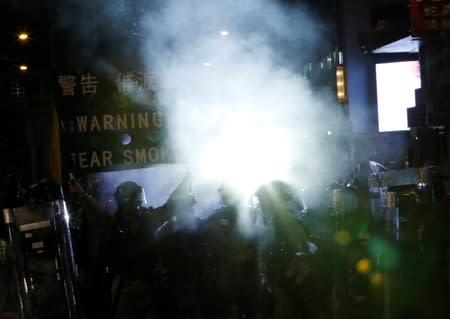 Police officers hold a banner that warns protesters for tear gas, during an anti-extradition protest in Hong Kong