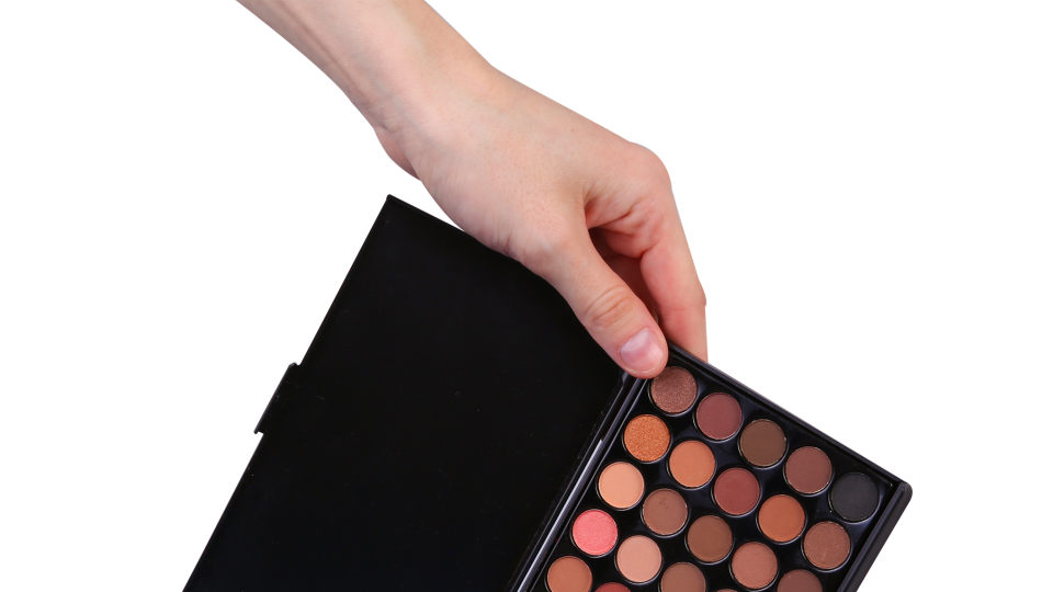 a hand holding an eyeshadow palette
