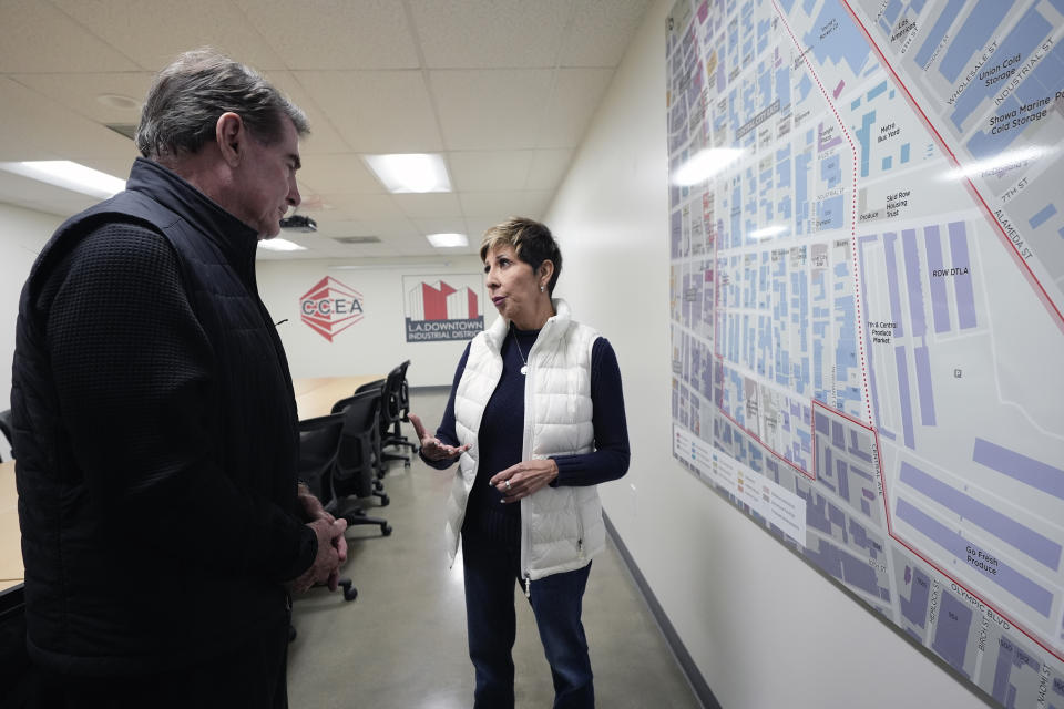 Estela Lopez Executive Director of the Los Angeles Downtown Industrial Business Improvement District shows former baseball player Steve Garvey a map of the homeless area of Skid Row in Los Angeles, on Jan. 11, 2024. The candidacy for the U.S. Senate of former California baseball star Garvey has brought a splash of celebrity to the race that has alarmed his Democratic rivals and tugged at the state's political gravity. (AP Photo/Richard Vogel)