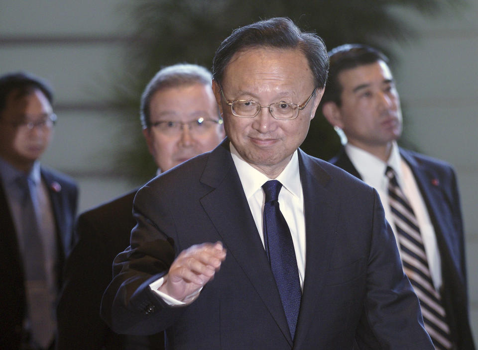 Chinese State Councilor Yang Jiechi greet media as he walks to meet Japanese Prime Minister Shinzo Abe at Abe's official residence in Tokyo Friday, May 17, 2019. (AP Photo/Eugene Hoshiko, Pool)