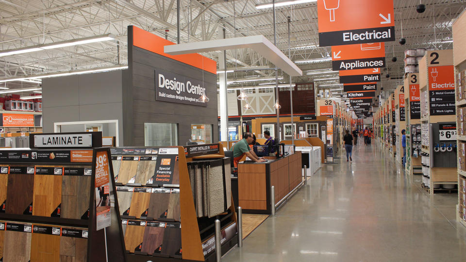 Inside of Home Depot store looking at aisle markers and laminate flooring.