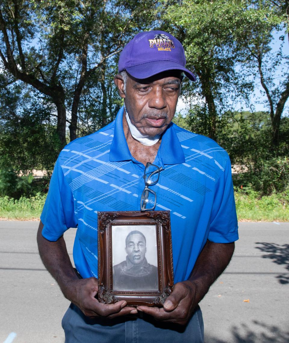 Gus Rich holds a photo of his father Roebuck Rich as he talks about his family's history along Persimmon Hollow Road in Milton on Friday, Aug. 18, 2023.