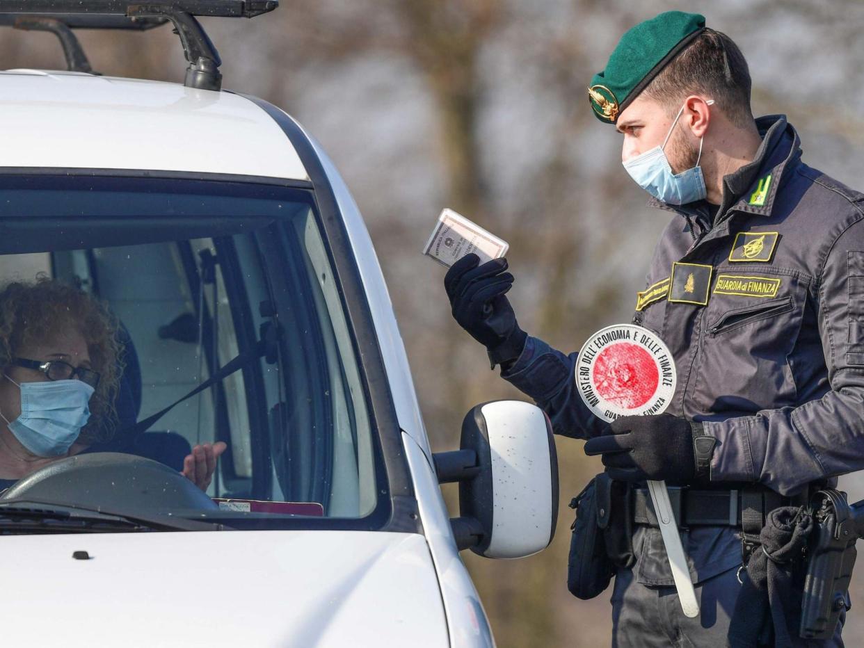 A guard talks to a driver at a checkpoint in Zorlesco, southeast of Milan: AFP/Getty