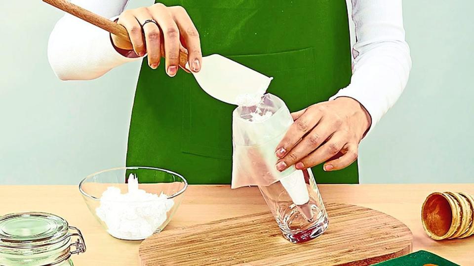 Woman using a spatula to put frosting in a pastry bag