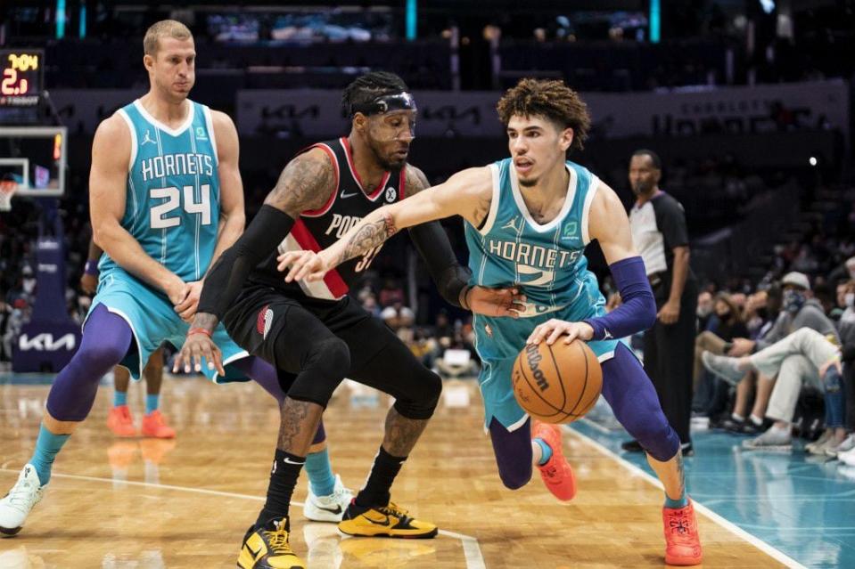 Charlotte Hornets guard LaMelo Ball (2) drives around Portland Trail Blazers forward Robert Covington (33) after Hornets center Mason Plumlee (24) set a screen during the first half of an NBA basketball game, Sunday, Oct. 31, 2021, in Charlotte, N.C. (AP Photo/Matt Kelley)