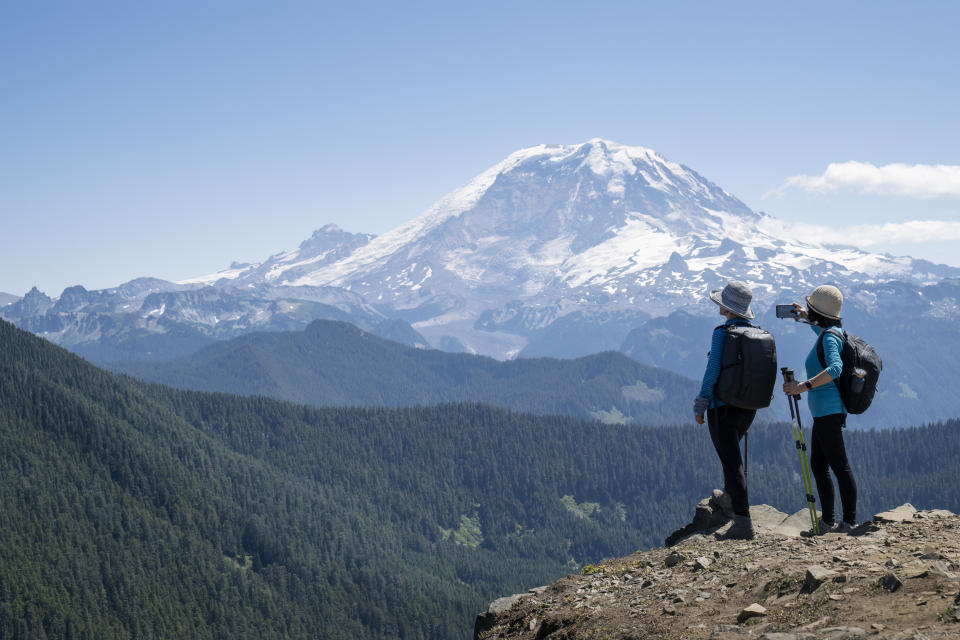 Two women looking over a beautiful mountain and trees on a hike