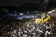 Riot police stand guard as protesters hold a rally outside the base of the 11th Infantry Regiment,a palace security unit under direct command of the Thai king, Sunday, Nov. 29, 2020 in Bangkok, Thailand. Pro-democracy demonstrators are continuing their protests calling for the government to step down and reforms to the constitution and the monarchy, despite legal charges being filed against them and the possibility of violence from their opponents or a military crackdown. (AP Photo/Sakchai Lalit)