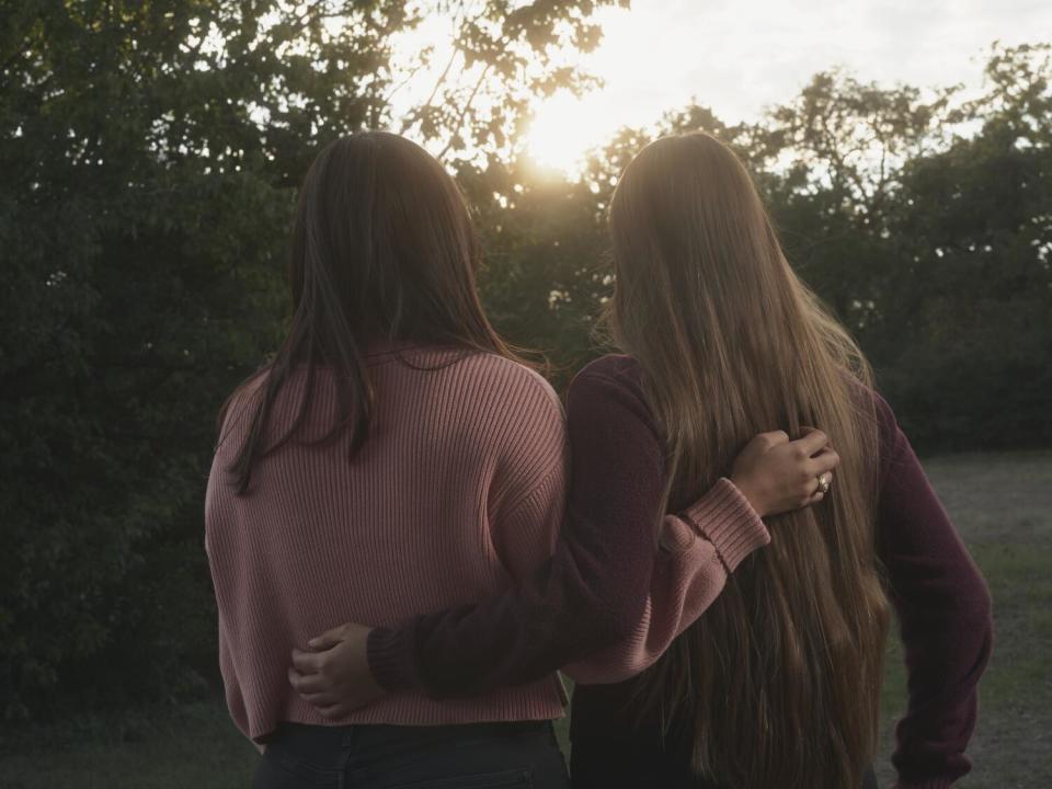 Twin sisters Janette Ortiz, left, and Judith Ortiz, right, take a break at a park