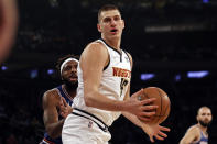 Denver Nuggets center Nikola Jokic (15) drives past New York Knicks center Mitchell Robinson during the first half of an NBA basketball game Saturday, Dec. 4, 2021, in New York. (AP Photo/Adam Hunger)