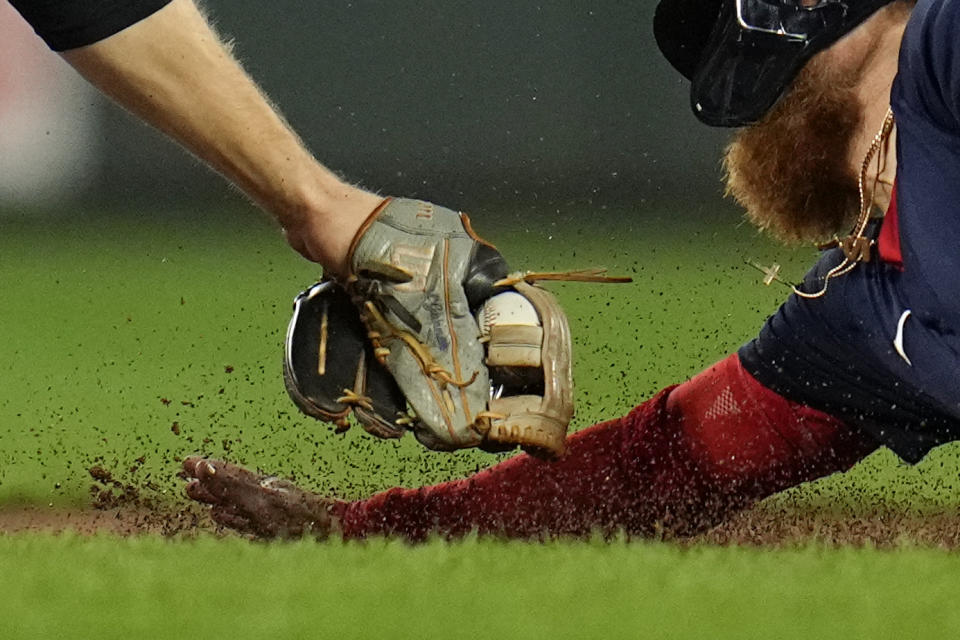 Baltimore Orioles shortstop Gunnar Henderson, left, tags out Boston Red Sox's Justin Turner trying to steal second base to end the top of the third inning of a baseball game, Saturday, Sept. 30, 2023, in Baltimore. (AP Photo/Julio Cortez)