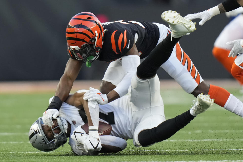 Las Vegas Raiders' Zay Jones (7) is tackled by Cincinnati Bengals' Chidobe Awuzie (22) during the first half of an NFL wild-card playoff football game, Saturday, Jan. 15, 2022, in Cincinnati. (AP Photo/AJ Mast)